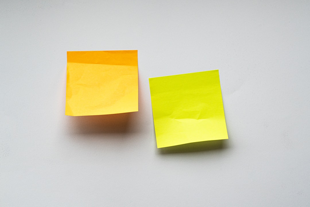 Orange and yellow sticky notes on a white wall